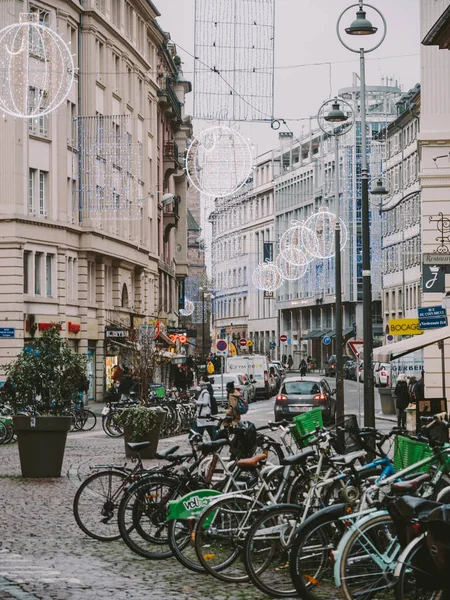 Duży parking dla rowerów w centrum Strasburga z widokiem na prawie pustą ulicę dzięki COVID z wieloma wiszącymi dekoracjami świątecznymi — Zdjęcie stockowe