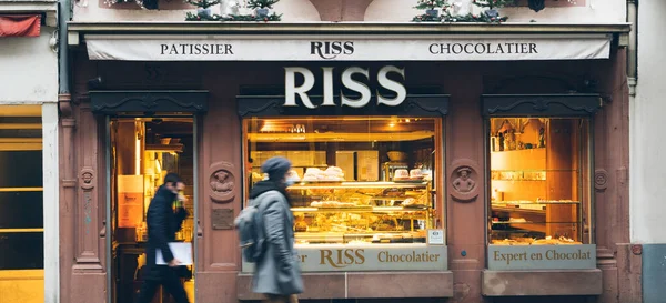 Fotgjengere som går foran Ross Patissier Sjokoladefabrikk midt i Strasbourg - byens ikoniske landemerke som selger deilige kaker og brød – stockfoto