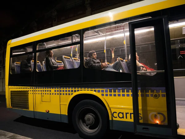 Scena notturna con i portoghesi uomini donne all'interno del bus giallo di trasporto pubblico — Foto Stock