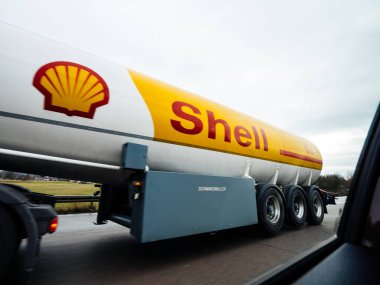Yakındaki Shell benzin tankeri karavanından geniş bir kütük tipi araba görüntüsü