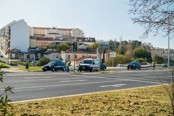 Citra warna jalan portugis besar dengan laki-laki menyapu dari aspahalt sisa mobil setelah kecelakaan jalan ringan — Stok Foto