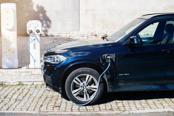 Zijaanzicht van nieuwe luxe BMW SUV auto wordt geladen met elektriciteit in de buurt van elektriciteitscentrale Mobile — Stockfoto