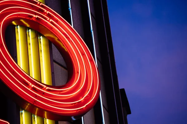 Vintage Neon light tubes forming letter O on the metallic roof top with dusk blue warm color skylight — Stock Photo, Image