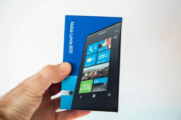 POV mannelijke hand met het pakket van de iconische blauwe Nokia Lumia 899 smartphone mobiele telefoon vervaardigd door de FInish bedrijf — Stockfoto