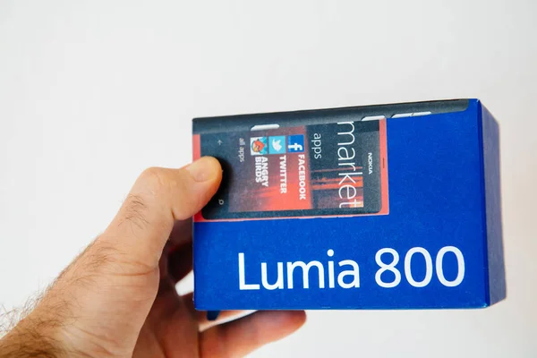 POV mannelijke hand met het pakket van de iconische blauwe Nokia Lumia 899 smartphone mobiele telefoon vervaardigd door de FInish bedrijf — Stockfoto