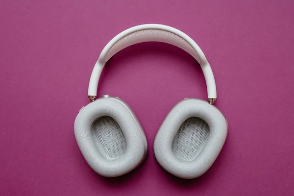 Nuevos Apple Computers AirPods Max auriculares sobre oreja contra fondo violeta limpio — Foto de Stock