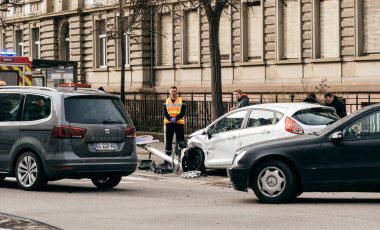 İnsanlar beyaz bir Ford Focus 'un yakınındaki kaza yerini gözetliyor.