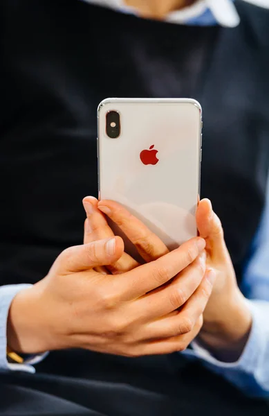 Geschäftsfrau in Großaufnahme, die neue Apple-Computer iPhone-Smartphone normal hortet - Fokus auf Hände mit Schriftzug der Rückseite des gläsernen Telefons — Stockfoto