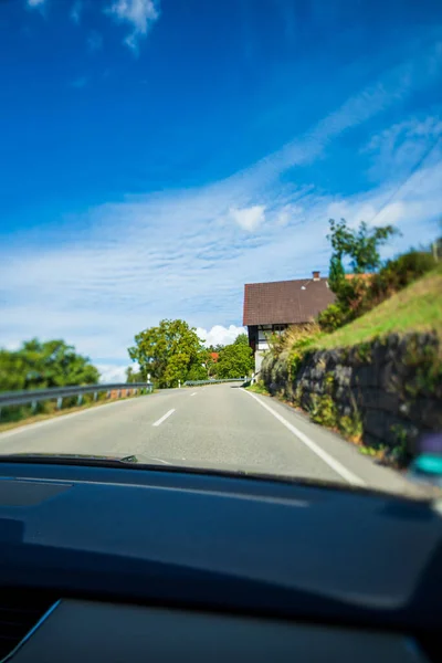 Tilt-shift shot of empty rural highway at high altitude in Black Forest mountains with hotel in the right — Foto de Stock