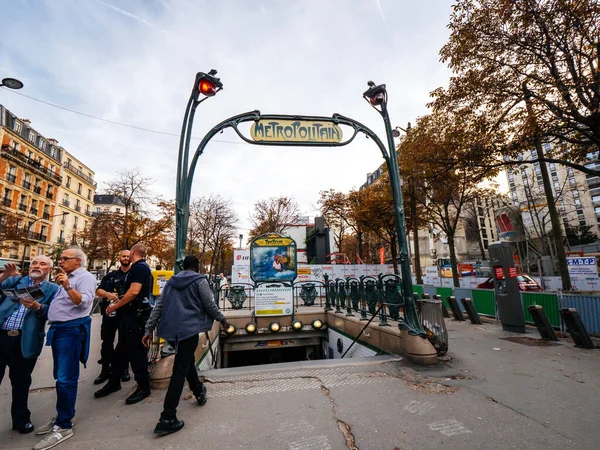 Pařížská pouliční scéna se spoustou chodců a policistů u vchodu do stanice metra Metropolitain v secesním stylu — Stock fotografie