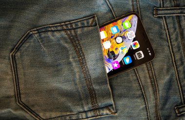 OLED retina ekranı ve ekranda birden fazla uygulama içeren yeni Apple Bilgisayarlı Akıllı Telefonun kot pantolonlarının arka cebi