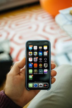 POV erkek eli yeni Apple Bilgisayarları iPhone akıllı telefonu birden fazla uygulama içeren ana ekranla tutuyor