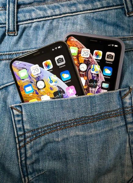 Hátsó nézet farmer hátsó zsebében az új Apple Computers Smartphone iPhone 11 X-ek kicsi és nagy Max verziók jellemző dupla kamera - arany színű telefon — Stock Fotó