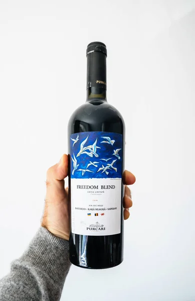 POV hane håller flaska med rött vin Freedom Blend av Purcari vingård från Republiken Moldavien — Stockfoto