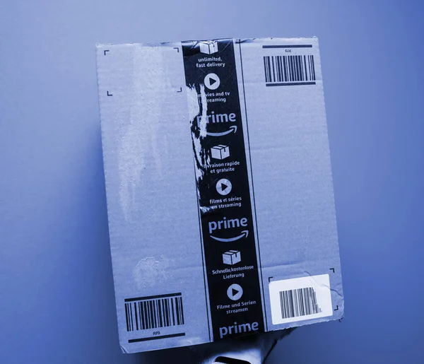 POV male hand holding new package of Amazon prime carton delivered with the iconic scotch tape in multiple languages and Prime logo — Φωτογραφία Αρχείου