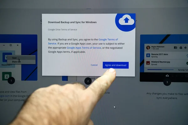 POV mano maschile premendo sul touch screen il pulsante di accordo e download del Backup e sincronizzazione dal software Google per Windows — Foto Stock