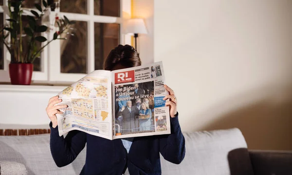Газета с заголовком "Новый день поднимается, показывая последние новости и заголовки с инаугурацией Джо Байдена" — стоковое фото
