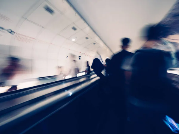 Blurred motion silhouettes of unrecognizable male with backpack inside Parisian underground metro moving escalator walkway taking the fastest route Royalty Free Stock Images