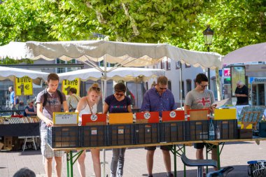 Sıcak bir yaz gününde eski bit pazarına bakan beş kişi çizgi roman ve vinil müzik koleksiyoncusu eşyaları satın alıyor.