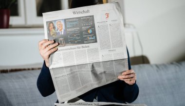 Frankfurter Allgemeine Alman gazetesini okuyan kadın, son dakika haberleri ve Joe Biden 'ın Amerika Birleşik Devletleri' nin 46. Başkanı ve Kamalla Harris 'in açılış töreniyle birlikte manşetlere çıktı.