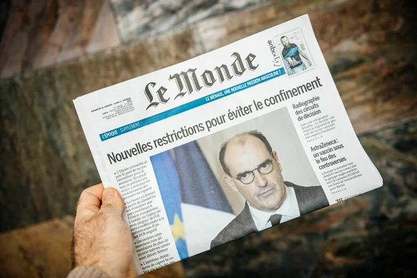 Мужчина, держащий за руку французскую газету Le monde с Жаном Кастексом на обложке о новой блокировке из-за пандемии коронавируса COVID-19 — стоковое фото