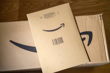 İki Amazon Prime kartonunda bir büyük kutu ve içinde birden fazla nesne olan bir zarf var. Amazon.com Jeff Bezos tarafından kuruldu