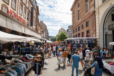 Büyük Braderie sırasında Strasbourg caddesinde yürüyen büyük bir kalabalık - sokak fuarı yıllık satış etkinliği - Monoprix mağazası yakınlarında indirimde olan kıyafetler ve çeşitli eşyalar