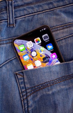 OLED retina ekranı ve ekranda birden fazla uygulama içeren yeni Apple Bilgisayarlı Akıllı Telefonun kot pantolonlarının arka cebi