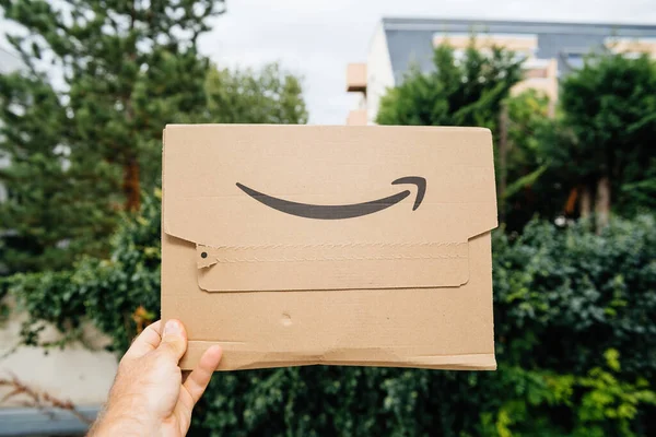 Pov male hand holding new package of Amazon Prime cardboard package — Stock Photo, Image