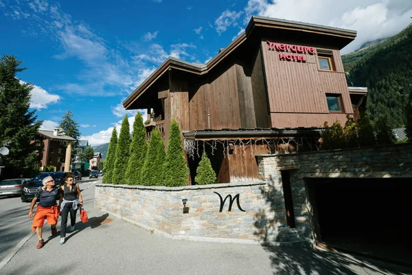 Pareja de adultos caminando frente al Accor Mercure Hotel en el centro de Chamonix — Foto de Stock