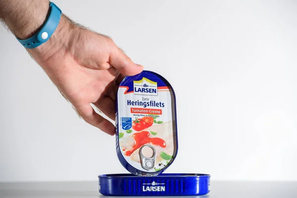 Mannelijke hand met presentatie van de verpakking van Larsen Zarte heringsfilet — Stockfoto