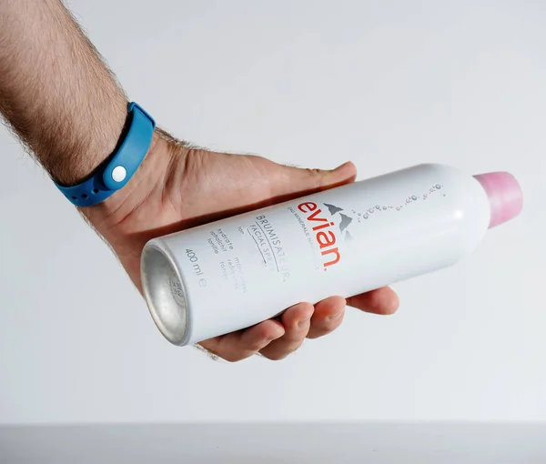 Mão masculina segurando Evian Facial Spray garrafa para ser usado em dias quentes de verão — Fotografia de Stock