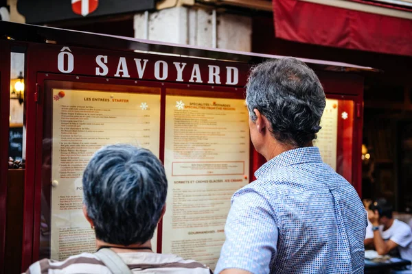 Vista traseira do menu de leitura dos clientes no restaurante O Savoyard — Fotografia de Stock