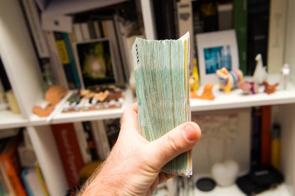 Mão masculina segurando grande pilha de milhares de euros — Fotografia de Stock