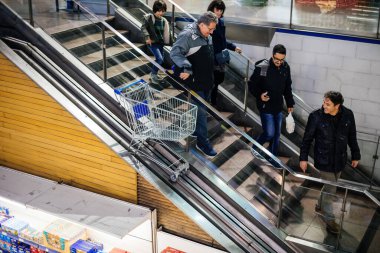 Yürüyen merdivenden bakan mutlu bir grup insan.