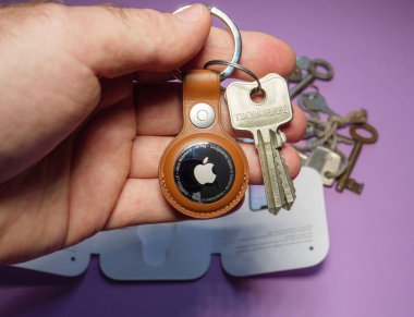 Paris, Fransa - 2 Mayıs 2021: Elma Bilgisayarlarının yeni AirTag 'ini Tschoeppe anahtarlarıyla gösteren adam - küçük aygıt, Apple Bul ağımı kullanarak kayıp anahtarları, cüzdanı, çantası gibi şeyleri bulmalarına yardımcı oluyor