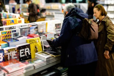 Kütüphanede kitap almak için alışveriş yapan iki yaşlı kadının arka görüntüsü