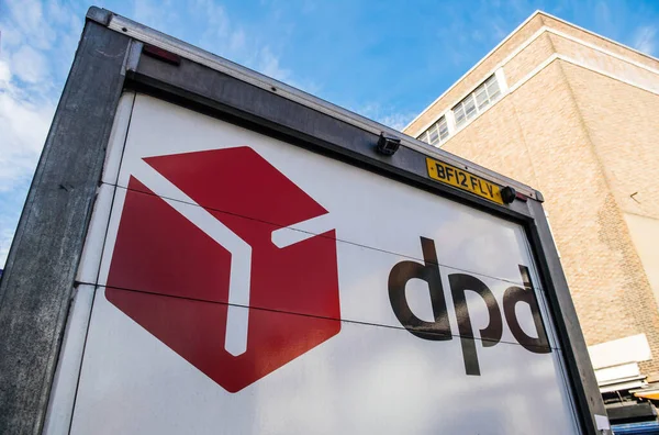 Låg vinkel syn på DPD paket leverans van tillbaka framför tegel byggnad — Stockfoto
