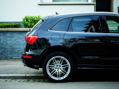 Evin önüne park edilmiş yeni lüks siyah Audi marka SUV.