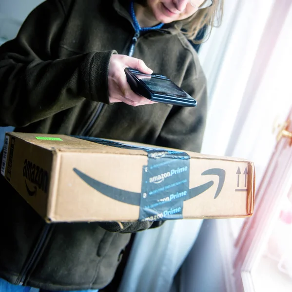 Kurierfrau Papppaket aus Amazon Prime-Lieferung — Stockfoto