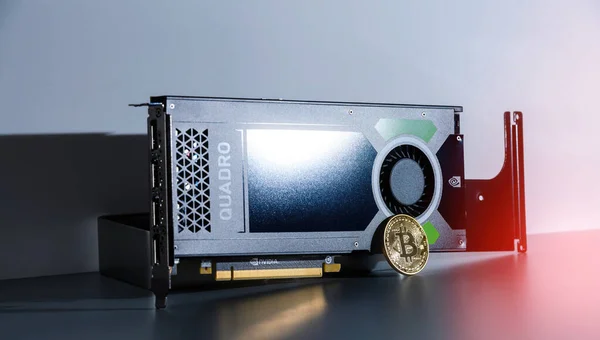 Bitcoin-Münze in Goldfarbe neben Nvidia GPU Quadro-Grafikkarte — Stockfoto