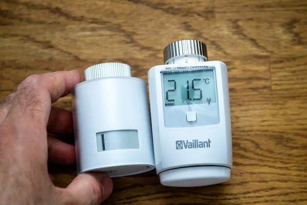 Segurando Netatmo por Stark cabeça termostática radiador inteligente uma marca de Legrand ao lado de Vaillant Ambisense — Fotografia de Stock