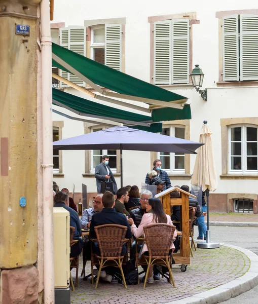 Side view of young people eating drinking at the terrace of French restaurant — Stock Photo, Image