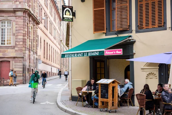 Side view of young people eating drinking at the terrace of Le Rimini — Stock Photo, Image