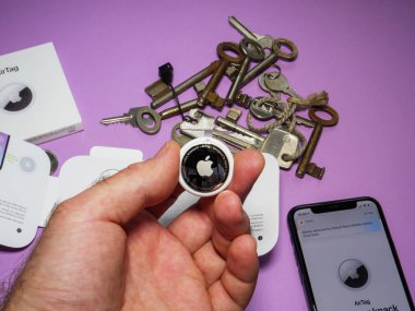 Man pov arka planda birden fazla anahtarı olan yeni AirTag ve iphone tutuyor