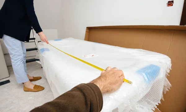 Woman and man measuring in new house the bathtub delivered during the renovation — Stock Photo, Image