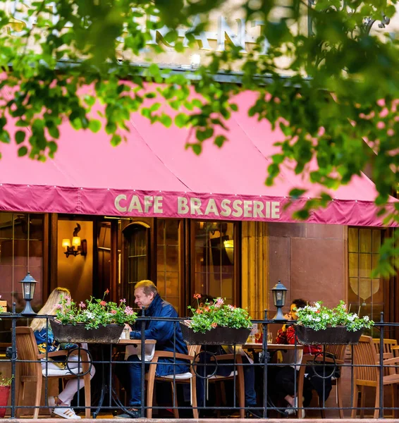 People eating outside at Cafe Brasserie as bars and restaurants — Stock Photo, Image