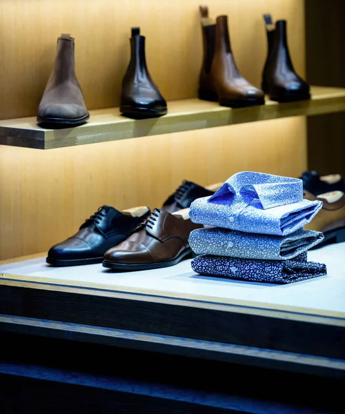 Showcase de loja de moda masculina com sapatos de couro de luxo e camisas coloridas — Fotografia de Stock