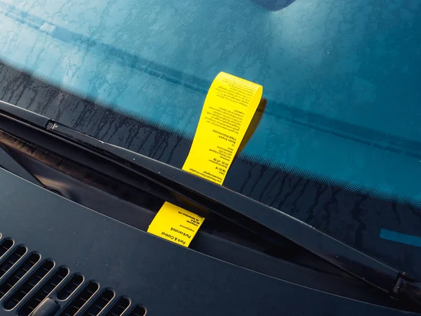 Yellow parking fine paper on the front glass windshield in German city — Stock Photo, Image