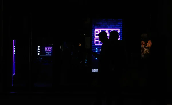 Decosued silhouettes of customers in front of Neon signage Black Friday — Stock Photo, Image